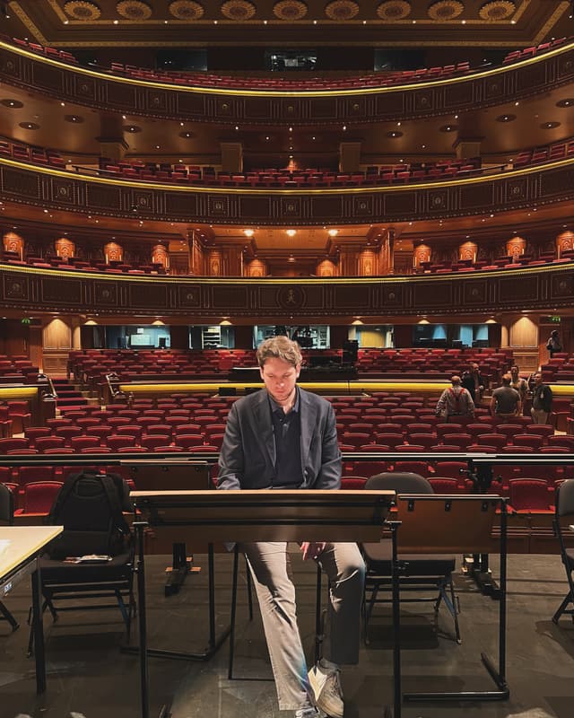 Davide Massiglia sitting in front of a beautiful theatre